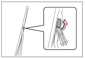 Flathead screwdriver lifting the windshield wiper blade stopper