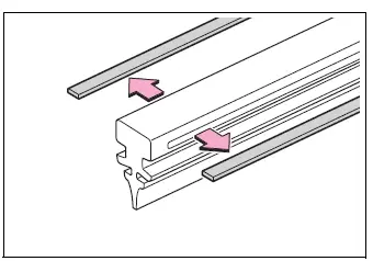 Metal support plates being transferred to the replacement rear wiper insert