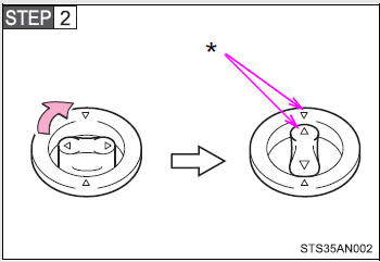 Turn the upper knob of each retaining hook (clip) to secure the floor mats in