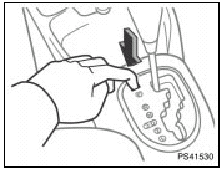 3. Insert your finger into the hole to push down the shift lock override button.